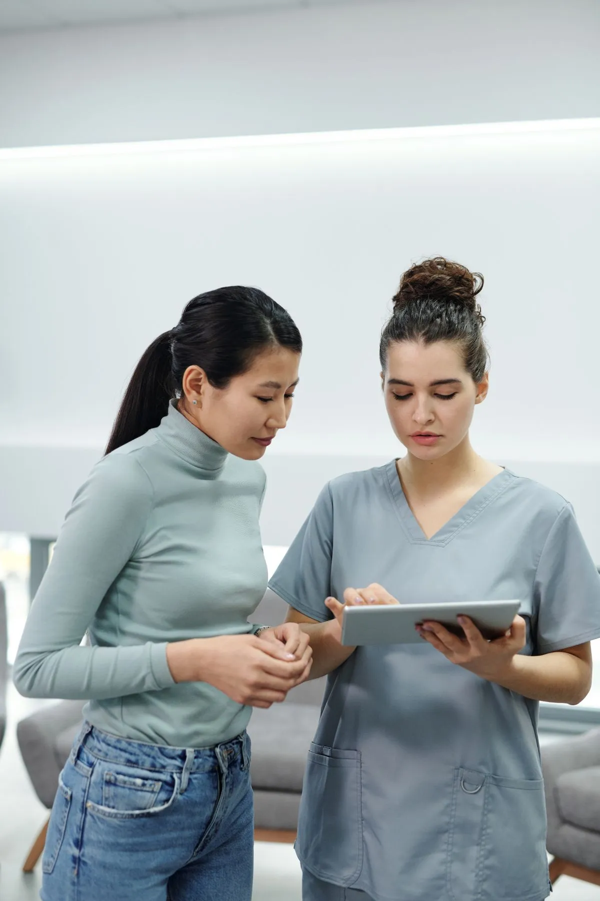 A healthcare professional sharing information with a patient on a tablet